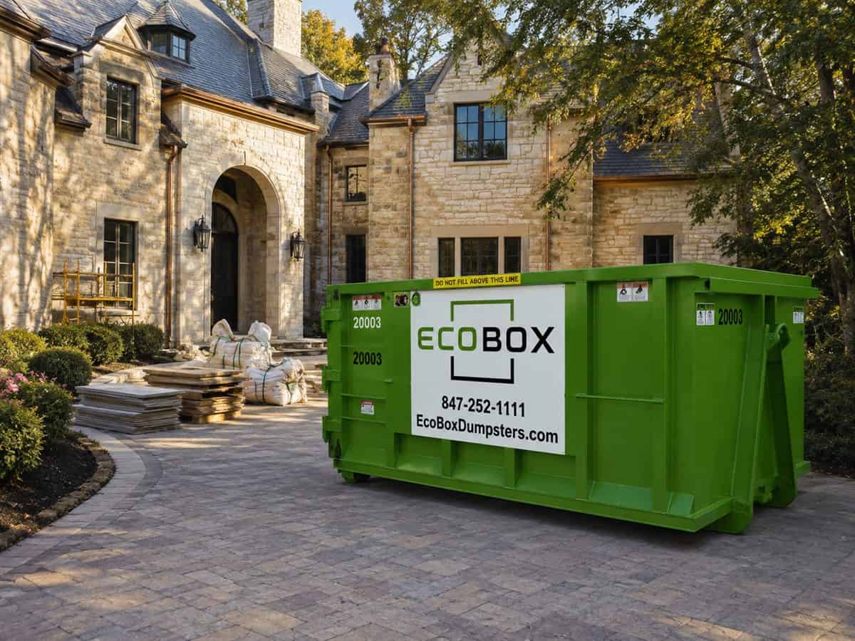 A roll-off dumpster on the driveway of a home being renovated