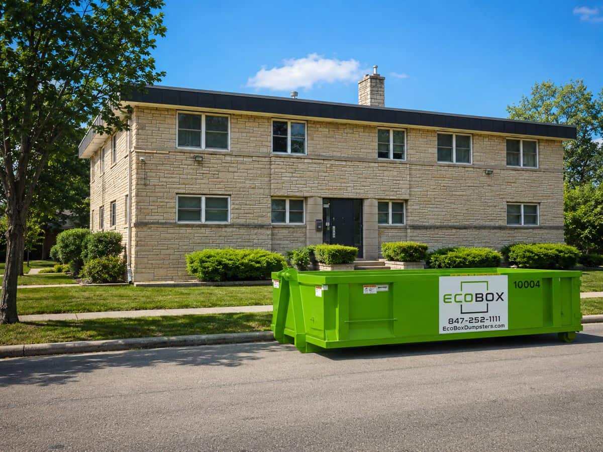 A roll-off dumpster on the driveway of a home being renovated